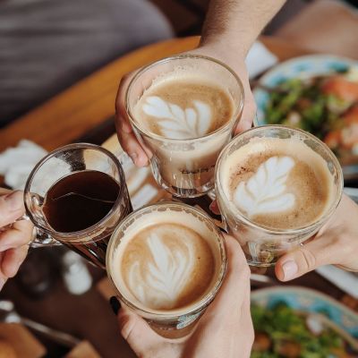 Hands holding coffee drinks doing cheers