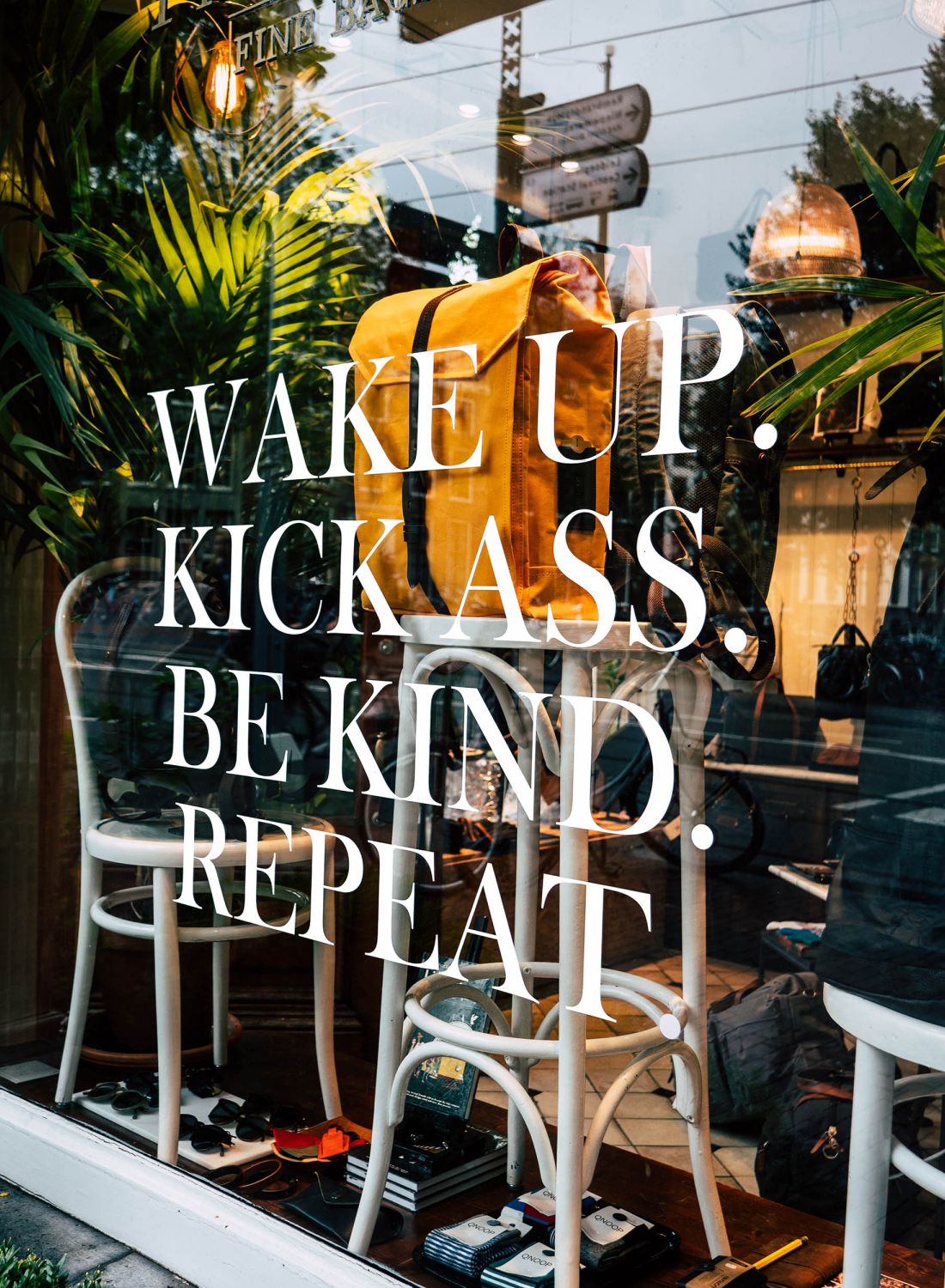 Signage on glass window in front of eclectic shop